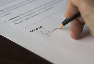 hand with pen signing a document hand with pen signing a document
