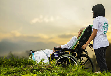 young lady pushing an elderly woman in a wheelchair