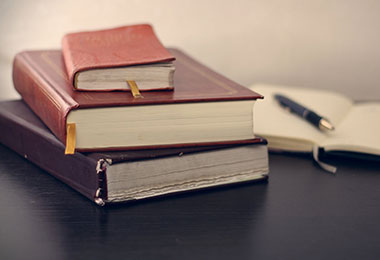 stack of brown books on a table