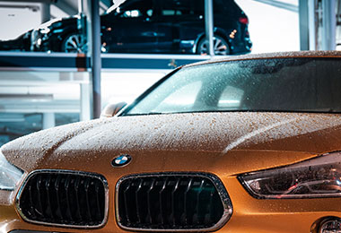 closeup of the front of a luxury car with condensation on it