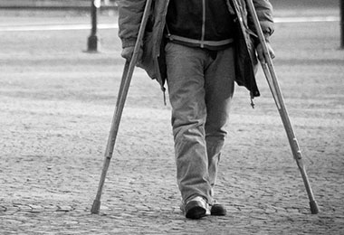 man using crutches to walk on street